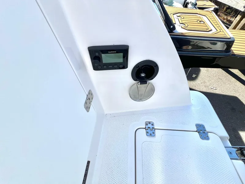 Slide: The Image of 2025 Sailfish 245 DC boat interior with control panel and storage compartment. - 30