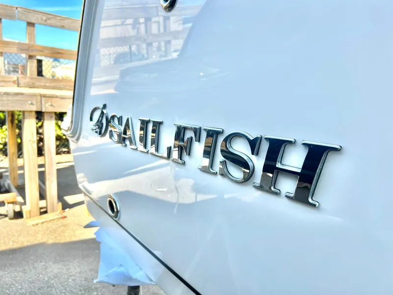 Slide: The Image of 2025 Sailfish 245 DC boat logo on white hull, close-up view. - 32