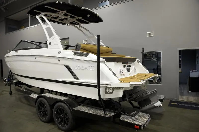 Slide: The Image of 2025 Cobalt R4 Surf boat on trailer in showroom, featuring sleek design and modern amenities. - 3