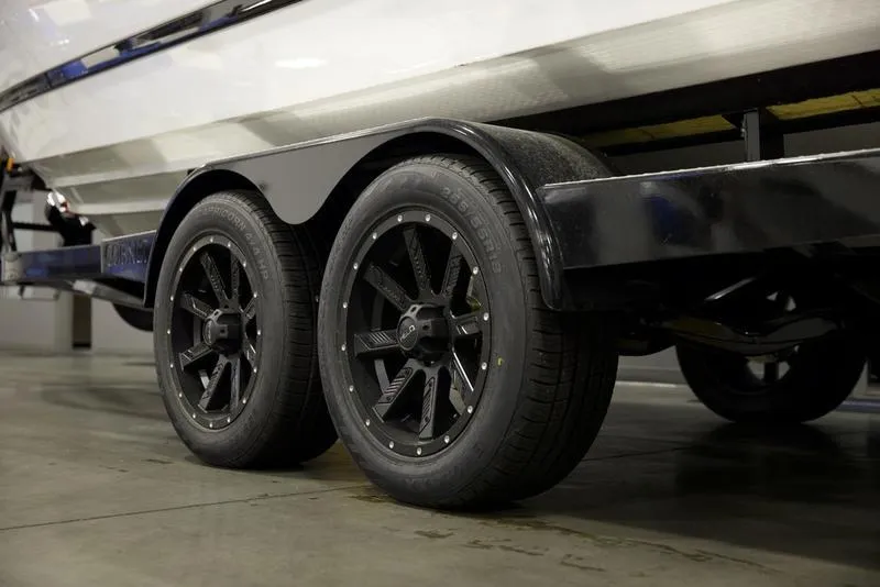 Slide: The Image of 2025 Cobalt R4 Surf boat trailer with black wheels in a garage. - 5