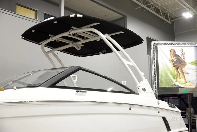 Slide: The Image of 2025 Cobalt R4 Surf boat with sleek design and black canopy in showroom. - 6