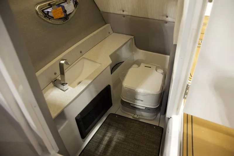 Slide: The Image of 2025 Cobalt R8 Surf boat interior with compact bathroom and portable toilet. - 16