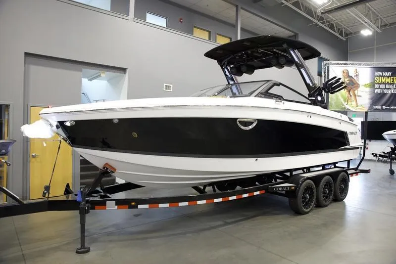 Slide: The Image of 2025 Cobalt R8 Surf boat on trailer in showroom. - 2