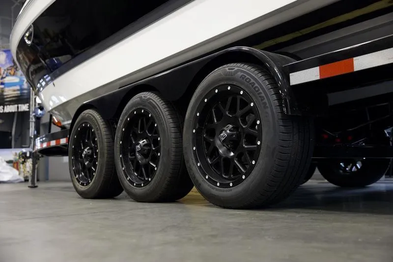 Slide: The Image of 2025 Cobalt R8 Surf boat trailer with black wheels in a showroom. - 5