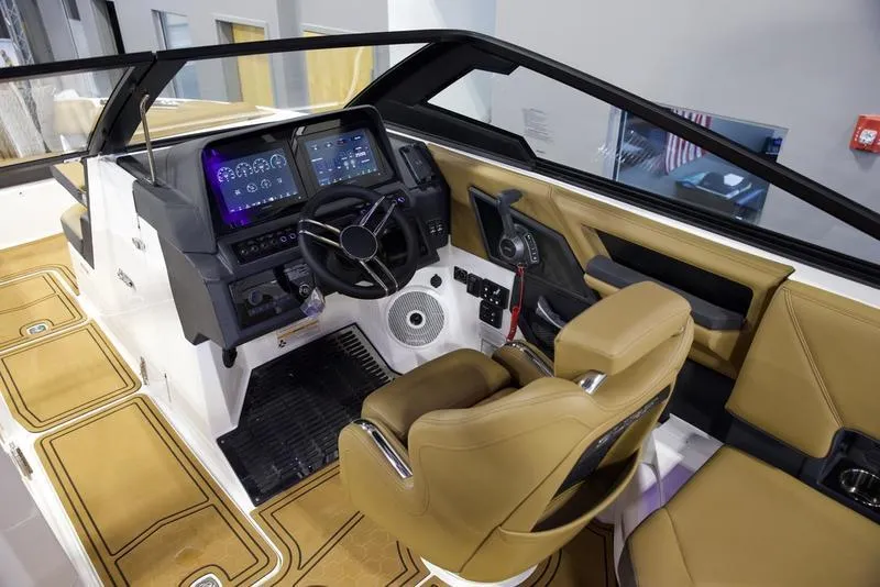 Slide: The Image of 2025 Cobalt R8 Surf boat interior with modern dashboard and tan seating. - 12