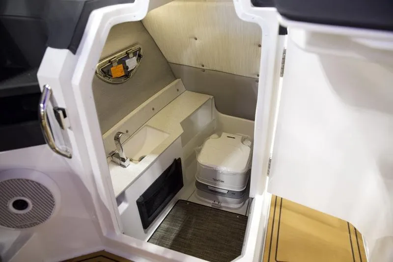 Slide: The Image of 2025 Cobalt R8 Surf boat interior with compact bathroom and modern amenities. - 19