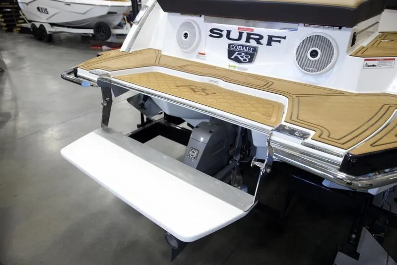 Slide: The Image of 2025 Cobalt R8 Surf boat with swim platform and speakers in showroom. - 6