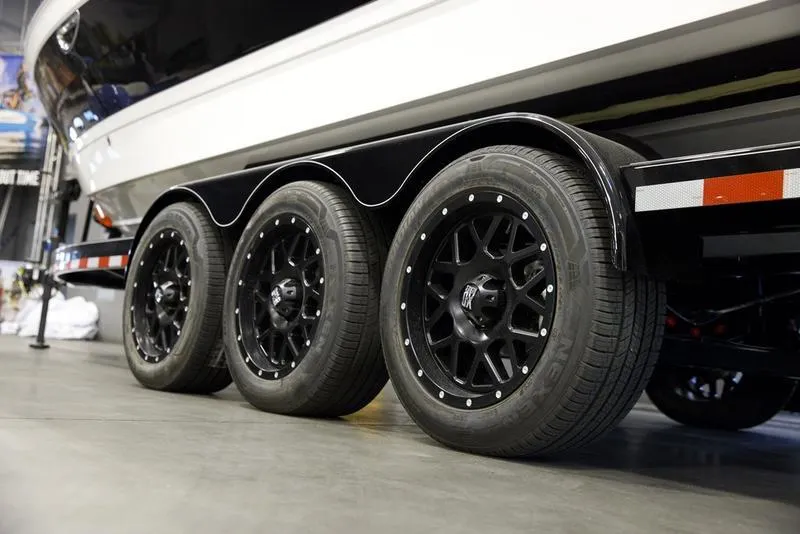 Slide: The Image of 2025 Cobalt R8 Surf boat trailer with triple black wheels in a showroom. - 7