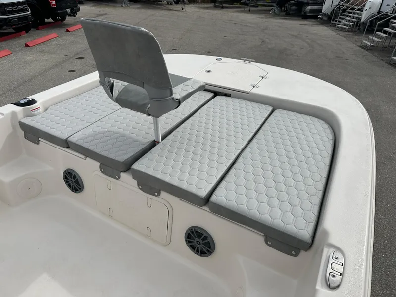 Slide: The Image of 2025 Carolina Skiff 21 LS boat with gray cushioned seating and storage compartments. - 10