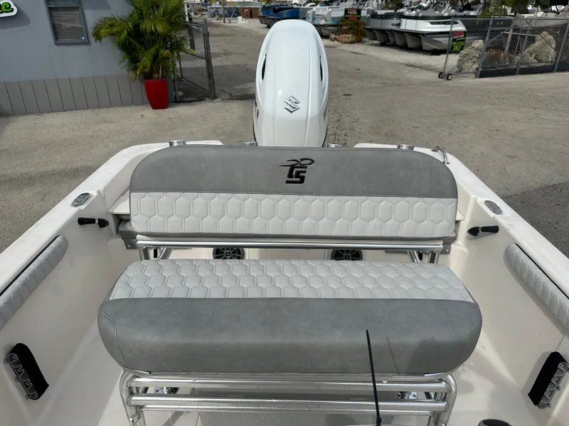 Slide: The Image of 2025 Carolina Skiff 21 LS boat interior with cushioned seating and outboard motor. - 13
