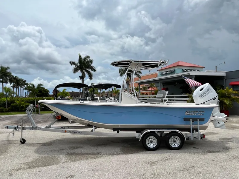 Slide: The Image of 2025 Carolina Skiff 21 LS boat on trailer, parked outdoors under cloudy sky. - 5