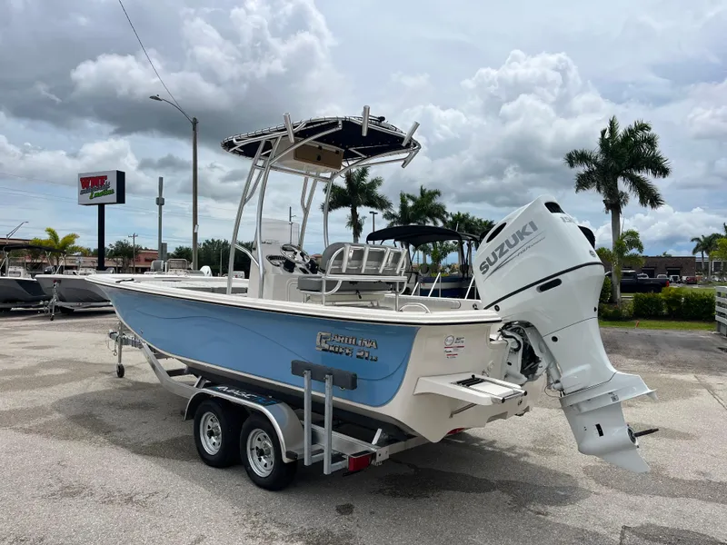 Slide: The Image of 2025 Carolina Skiff 21 LS boat on trailer with Suzuki outboard motor, parked outdoors. - 6