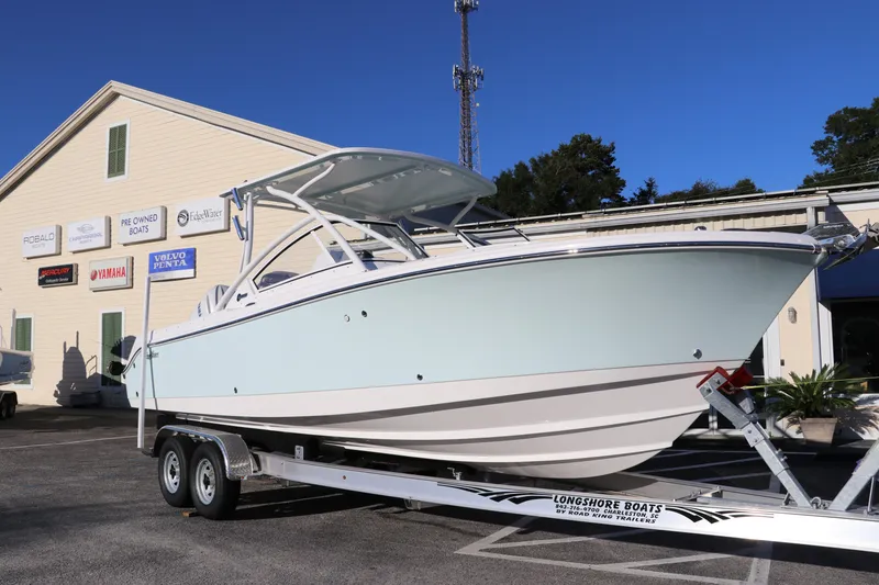 Slide: The Image of 2025 Edgewater 248 CX boat on trailer outside dealership. - 1