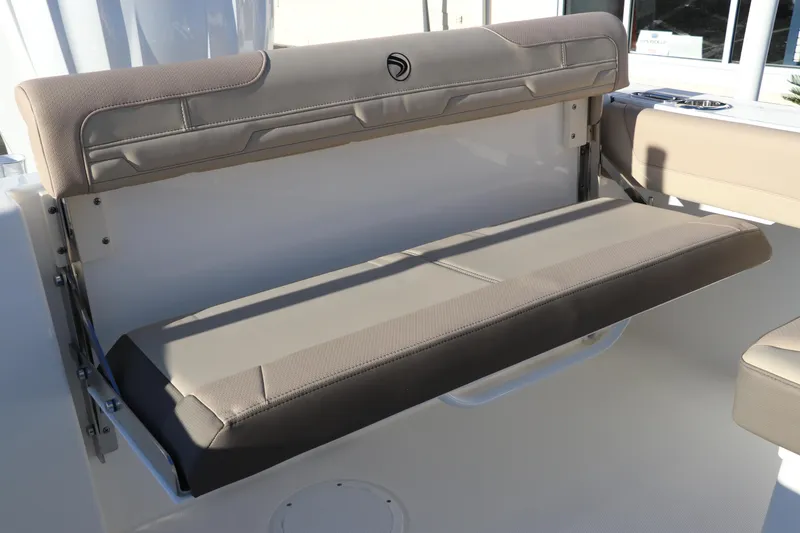 Slide: The Image of 2025 Edgewater 248 CX boat interior with beige seating and storage compartment. - 10