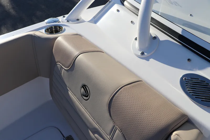 Slide: The Image of 2025 Edgewater 248 CX boat storage compartment with cup holders, white interior. - 42