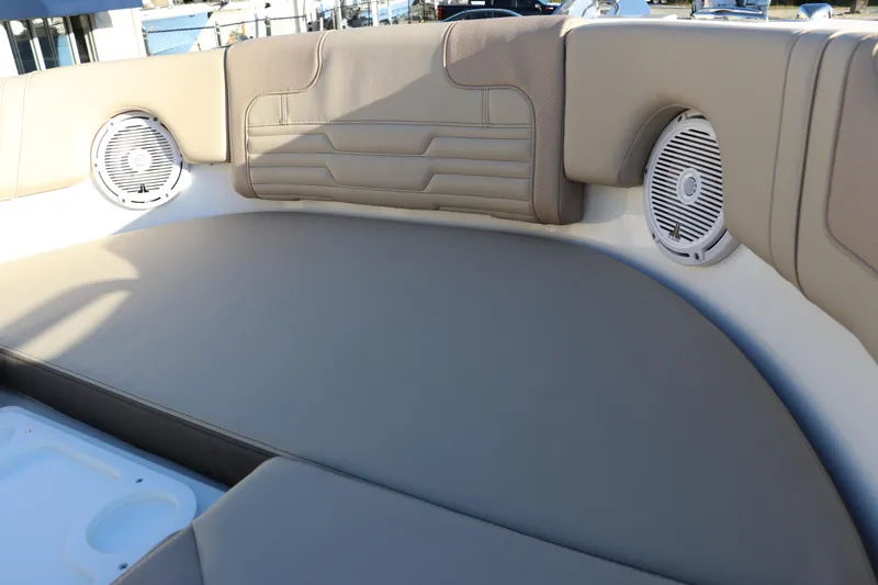 Slide: The Image of 2025 Edgewater 248 CX boat interior with beige seating and speakers. - 44