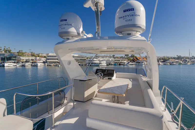 Slide: The Image of Azimut 55 Fly 2022 yacht flybridge with seating, table, and radar domes on a sunny day. - 41