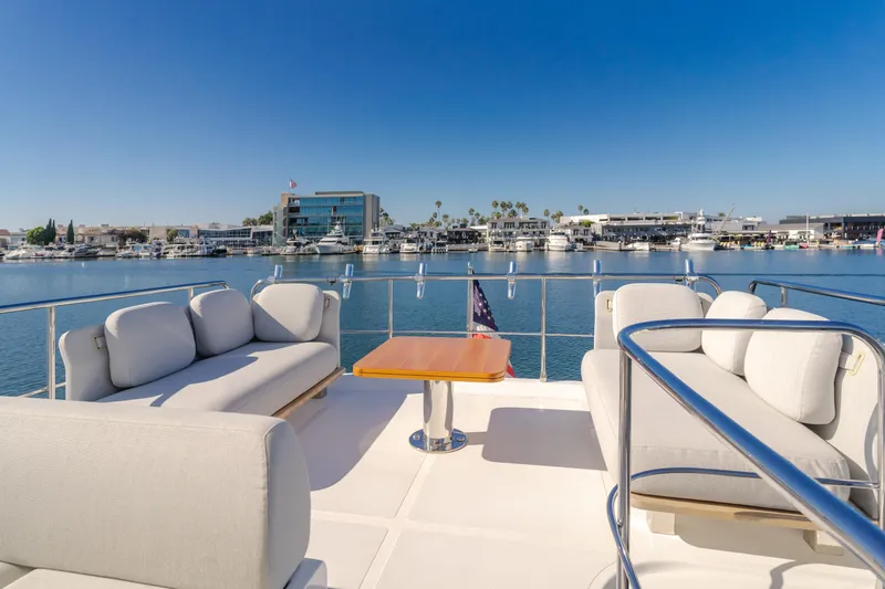 Slide: The Image of Azimut 55 Fly 2022 yacht deck with seating, overlooking marina and clear blue sky. - 43