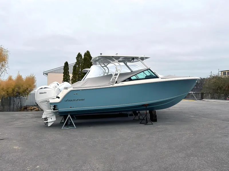 The Image of 2025 Sailfish 276 DC boat on stands, light blue hull, dual engines, outdoor setting. - 0