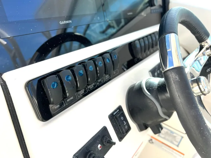 Slide: The Image of 2025 Sailfish 276 DC boat dashboard with steering wheel and control panel. - 19
