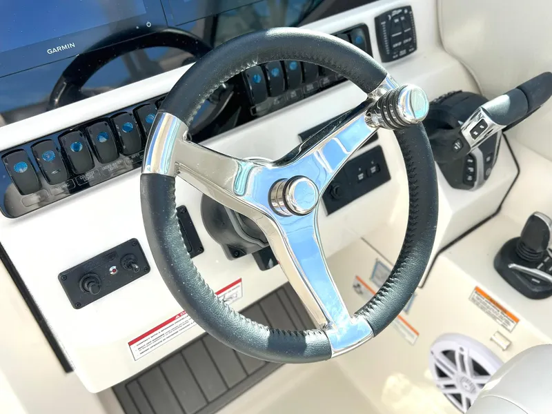 Slide: The Image of Steering wheel of 2025 Sailfish 276 DC boat with modern controls and dashboard. - 20
