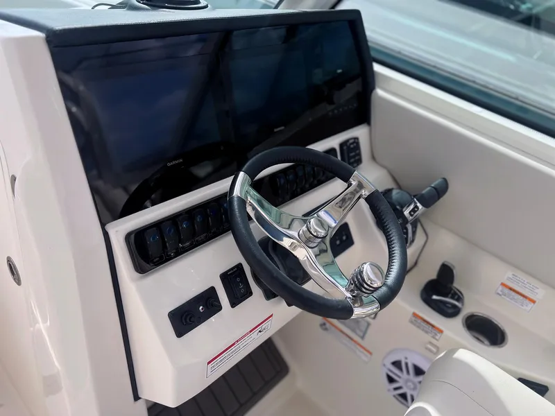 Slide: The Image of 2025 Sailfish 276 DC boat helm with modern controls and steering wheel. - 22