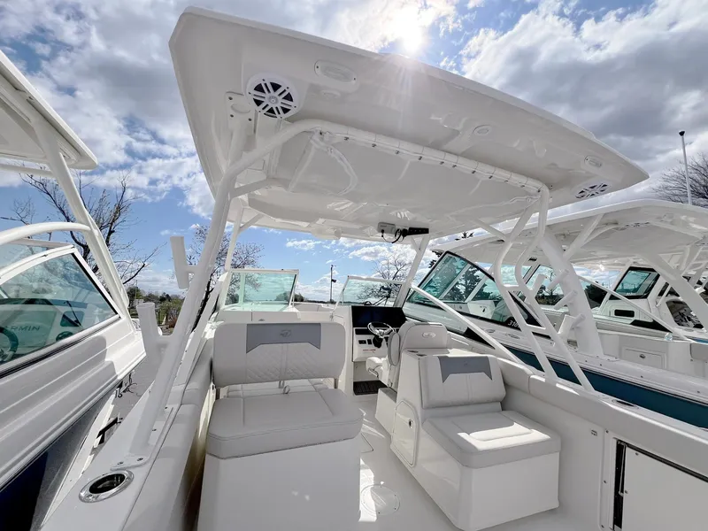 Slide: The Image of 2025 Sailfish 276 DC boat interior with seating and helm under sunny sky. - 29