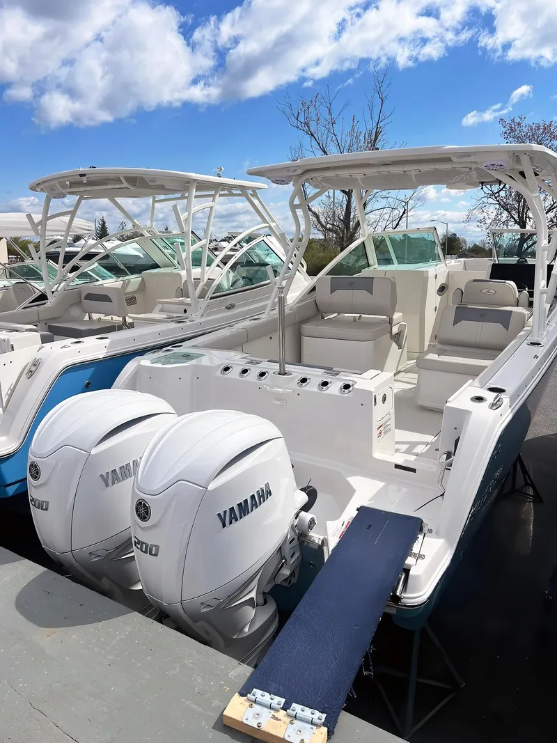 Slide: The Image of 2025 Sailfish 276 DC boat with twin Yamaha engines, docked under a blue sky. - 44