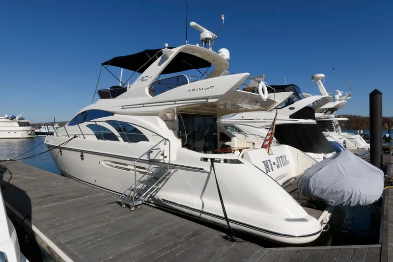 Slide: The Image of 2005 Azimut 50 Flybridge yacht docked at marina under clear blue sky. - 1