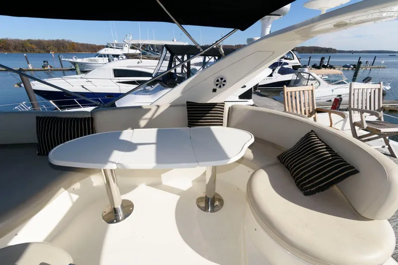 Slide: The Image of Azimut 50 Flybridge 2005 yacht with outdoor seating and table, docked at marina. - 10