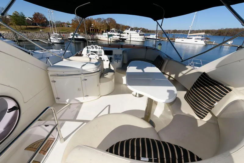 Slide: The Image of 2005 Azimut 50 Flybridge yacht interior with seating and table, docked at marina. - 11