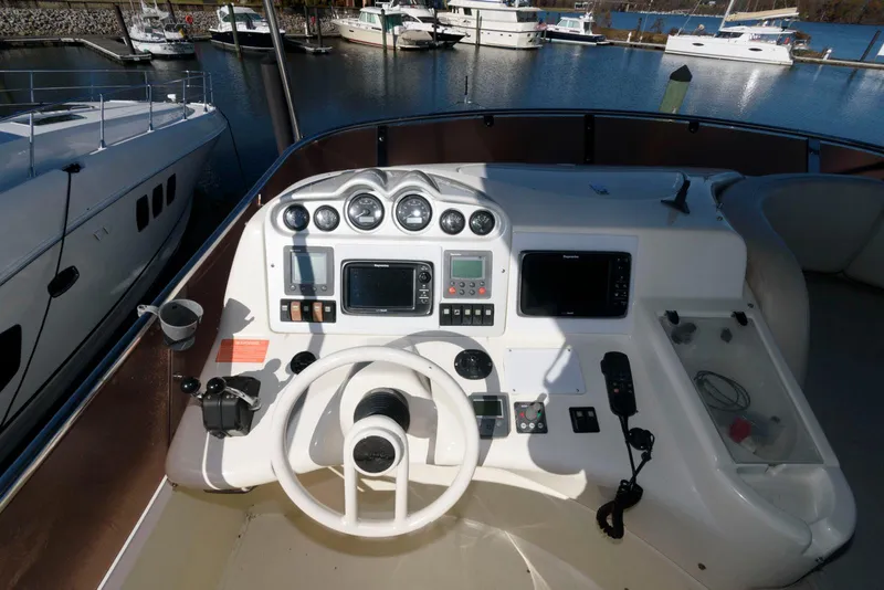 Slide: The Image of Azimut 50 Flybridge 2005 helm with navigation instruments and steering wheel, docked at marina. - 14