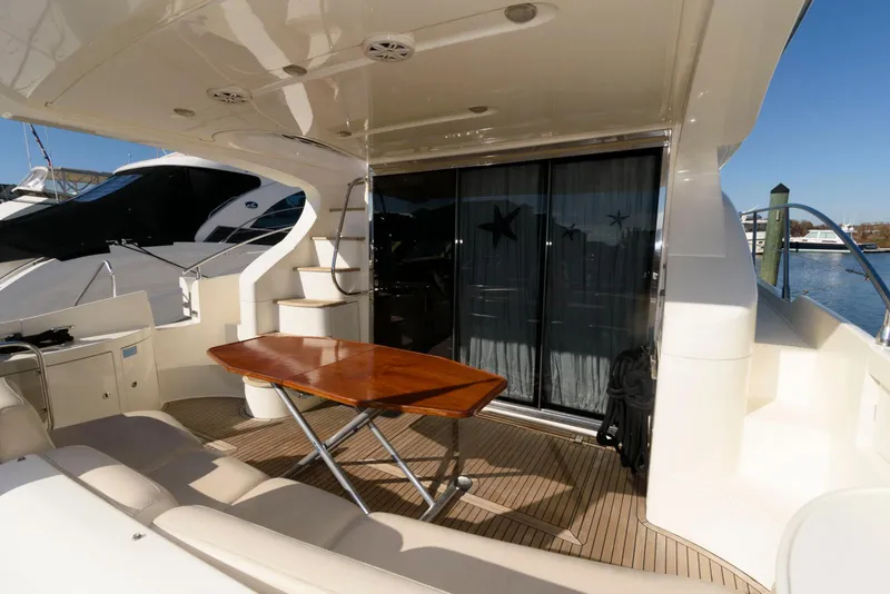 Slide: The Image of 2005 Azimut 50 Flybridge yacht deck with table and seating area. - 3