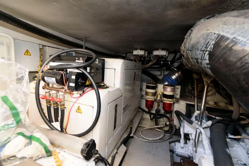 Slide: The Image of Engine room of 2005 Azimut 50 Flybridge yacht, showcasing mechanical components and wiring. - 35