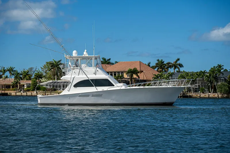 The Image of 1999 Post 50 Convertible yacht on water with palm trees and blue sky background. - 0