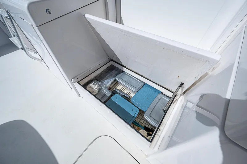 Slide: The Image of Storage compartment on 1999 Post 50 Convertible boat with organized containers. - 25