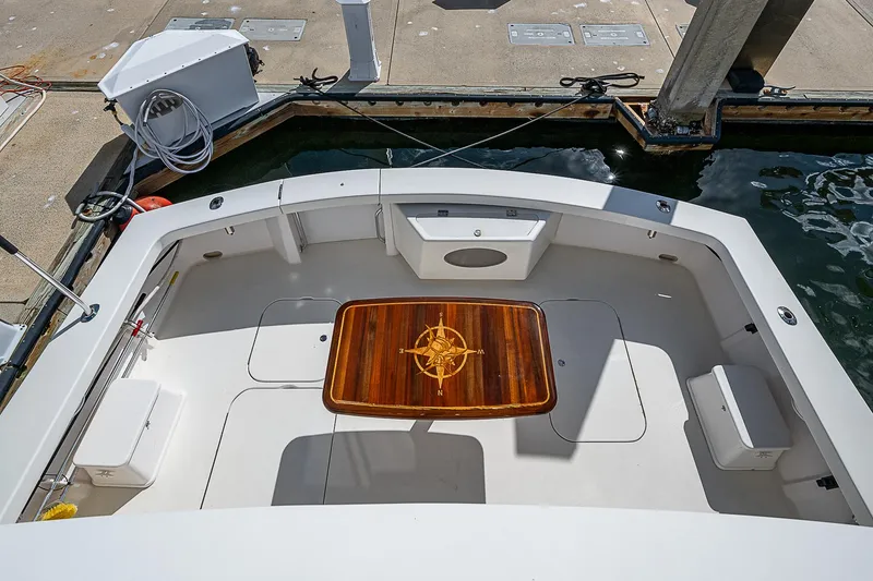 Slide: The Image of 1999 Post 50 Convertible boat deck with wooden table, docked at marina. - 31