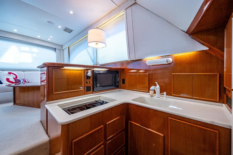 Slide: The Image of Luxurious 1999 Post 50 Convertible yacht kitchen with modern amenities and elegant wood cabinetry. - 52