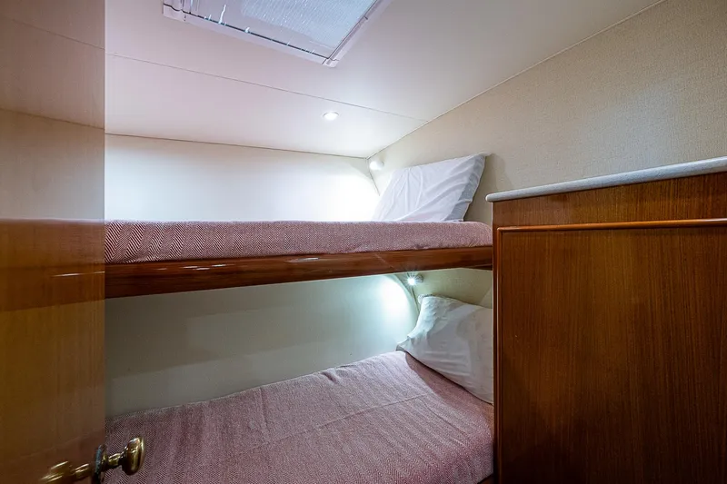 Slide: The Image of 1999 Post 50 Convertible yacht cabin with cozy bunk beds and soft lighting. - 53