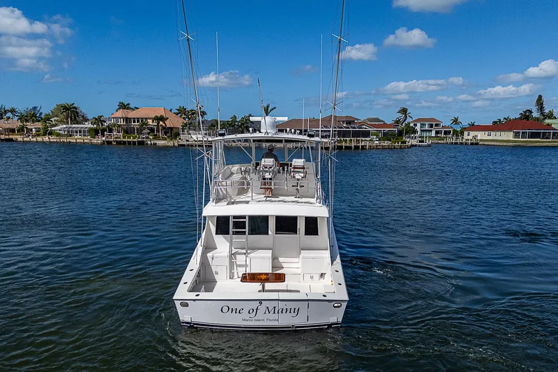 Slide: The Image of 1999 Post 50 Convertible yacht on water, clear sky, waterfront homes in background. - 8