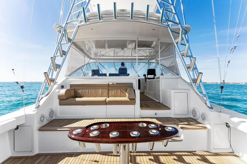 Slide: The Image of 2007 Viking 52 Open yacht interior with seating and fishing setup on a sunny day. - 19