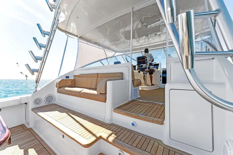 Slide: The Image of 2007 Viking 52 Open yacht interior with seating and helm, featuring teak flooring. - 25