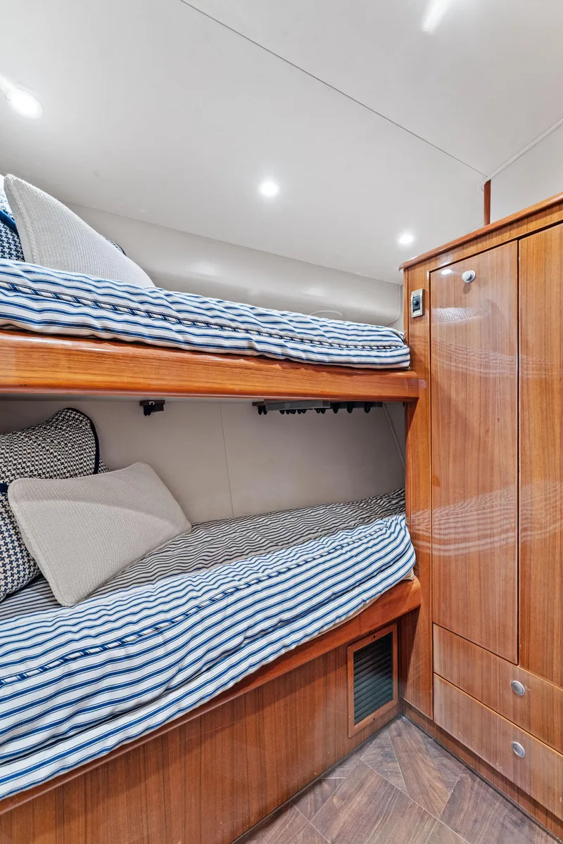 Slide: The Image of 2007 Viking 52 Open yacht cabin with wooden bunk beds and striped bedding. - 46