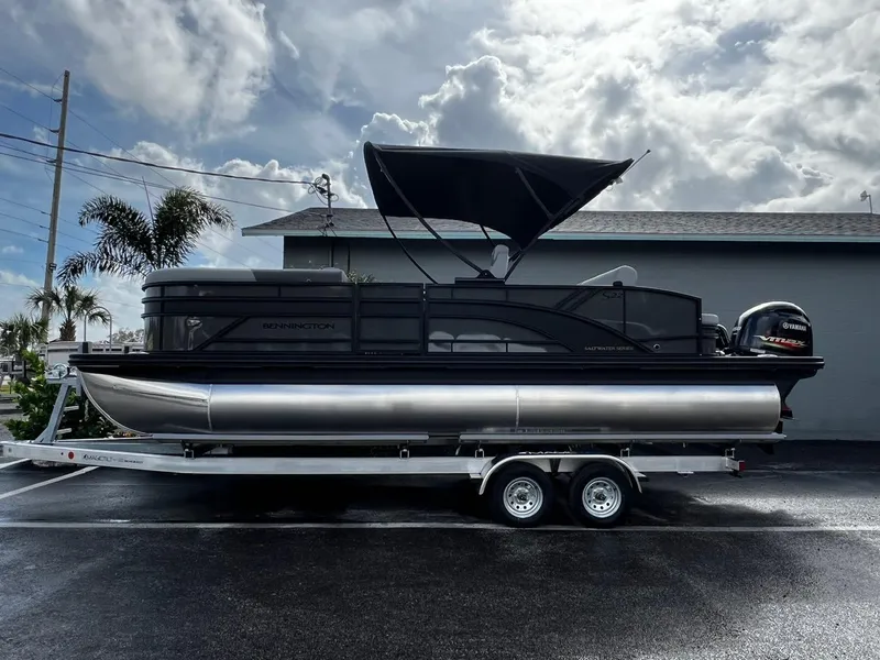 Slide: The Image of 2025 Bennington S 22 pontoon boat on trailer under cloudy sky. - 3