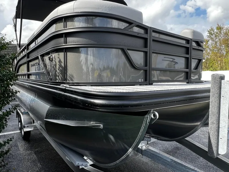 Slide: The Image of 2025 Bennington S 22 pontoon boat on a trailer, sleek design under cloudy sky. - 4