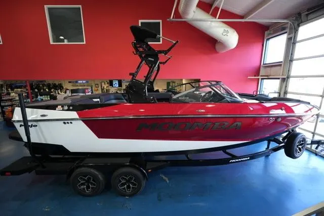 The Image of 2025 Moomba Mojo boat in showroom, red and white design, on trailer. - 1