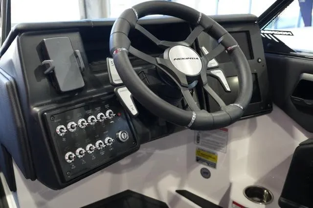 Slide: The Image of 2025 Moomba Mojo boat dashboard with steering wheel and control panel. - 12