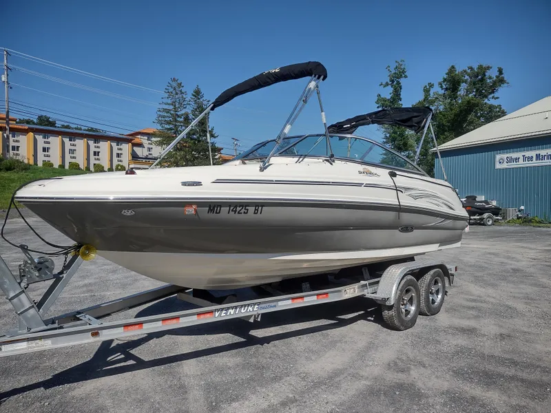 Slide: The Image of 2006 Sea Ray 200 Sundeck boat on trailer, parked outdoors. - 2