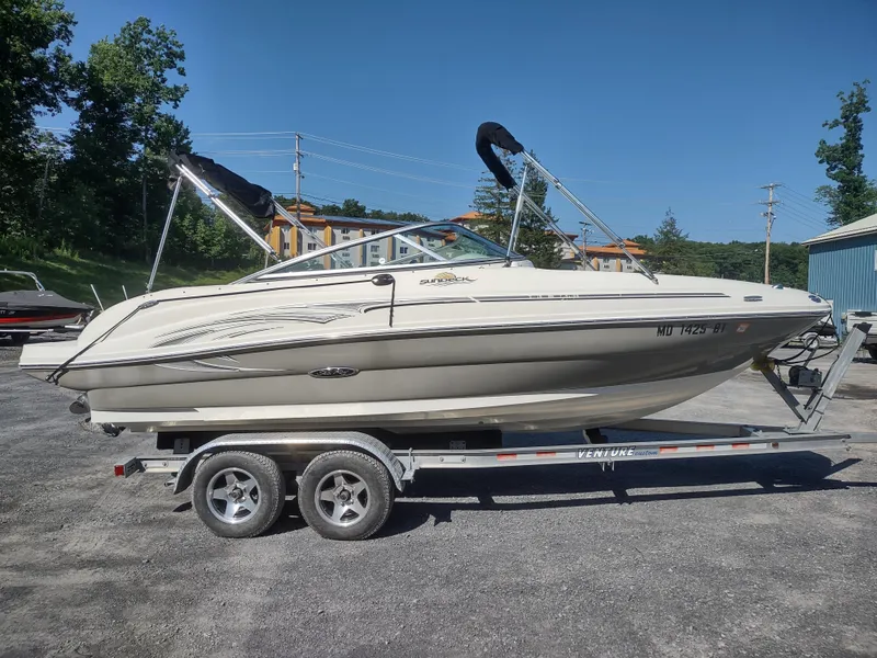 Slide: The Image of 2006 Sea Ray 200 Sundeck boat on trailer, parked outdoors. - 4