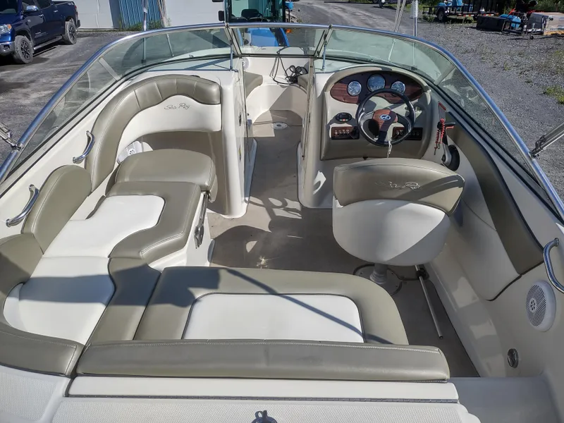 Slide: The Image of 2006 Sea Ray 200 Sundeck interior with beige seating and dashboard. - 6